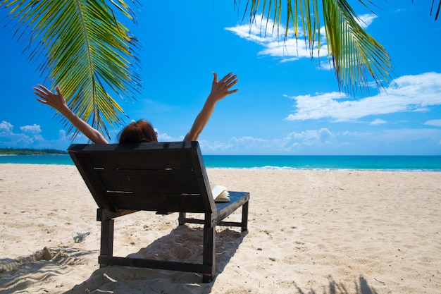 Feliz mujer se relaja en la playa