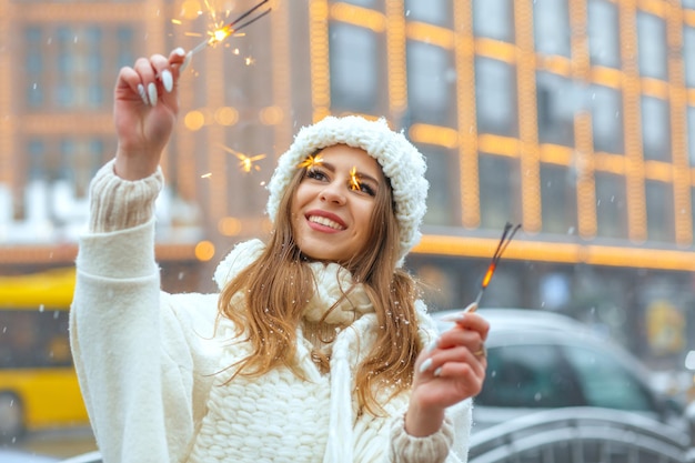 Feliz mujer rubia divirtiéndose con luces brillantes en la ciudad