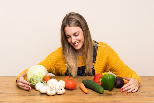 Foto feliz mujer rubia con muchas verduras