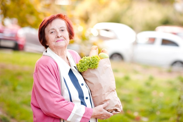 Feliz mujer senior sosteniendo el paquete con comida