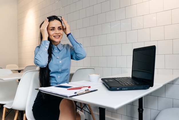 Feliz mujer sentada en un escritorio en la oficina