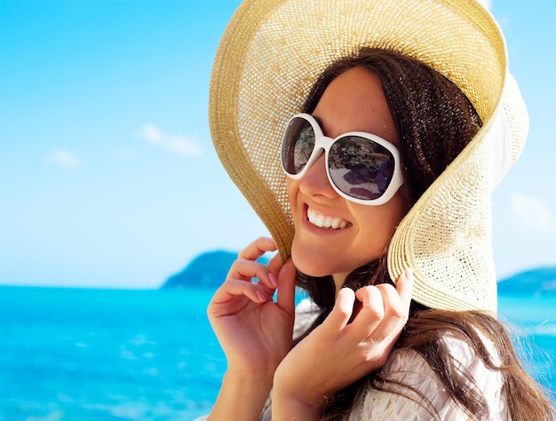 Feliz mujer con sombrero en la playa