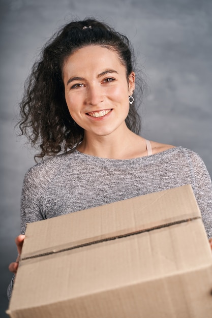 Feliz mujer sonriente recibió caja grande sosteniendo en sus manos