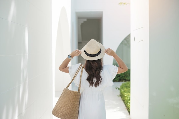 Feliz mujer viajera con vestido blanco y sombrero disfruta en tiempo de vacaciones Sudeste asiático viaje viaje y concepto de vacaciones de verano