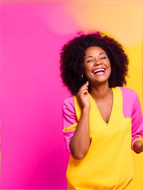 Feliz mulher afro-americana otimista em roupas cor-de-rosa coloridas rindo isoladas em backgro amarelo