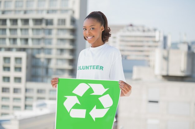 Feliz mulher altruísta segurando sinal de reciclagem