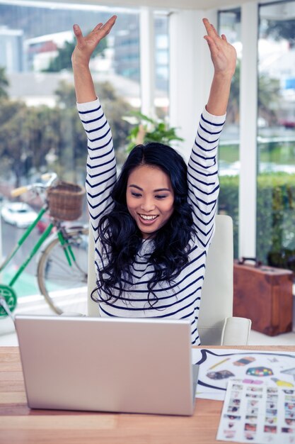 Feliz, mulher asian, com, braços levantaram, olhar, laptop, em, escritório