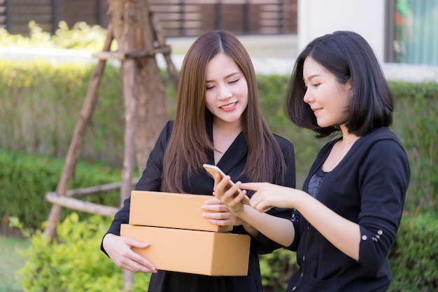 Feliz, mulher asian, usando, smartphone, para, loja, online, com, passe segurar, deliveried, pacote