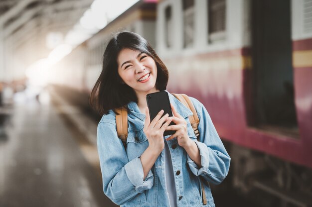 Feliz mulher asiática na estação de trem