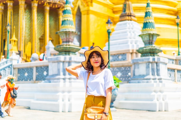 Foto feliz mulher asiática visitando o templo na tailândia