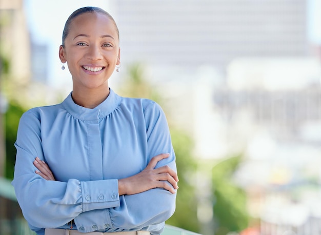 Feliz mulher de negócios confiante e sorridente em pé com os braços cruzados do lado de fora no trabalho sozinho Retrato do rosto de um profissional corporativo feminino alegre alegre e orgulhoso com os braços cruzados