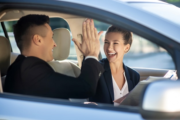 Feliz mulher e homem tocando boas-vindas no carro