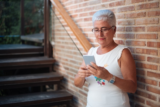 Feliz mulher idosa no telefone celular