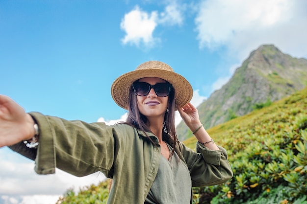 Feliz mulher jovem e bonita nas montanhas no fundo do nevoeiro