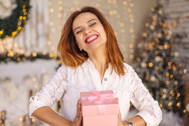 Feliz mulher jovem e bonita segurando uma caixa de presente