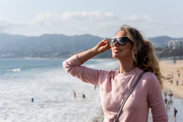 Feliz mulher loira na praia de los angeles