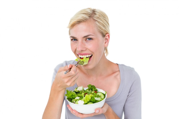 Feliz mulher loira segurando tigela de salada