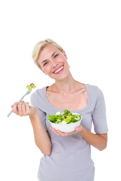 Feliz mulher loira segurando tigela de salada