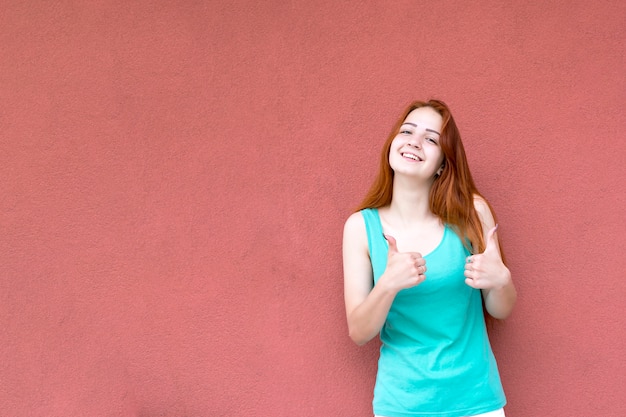 Feliz mulher ruiva sorridente, mostrando os polegares