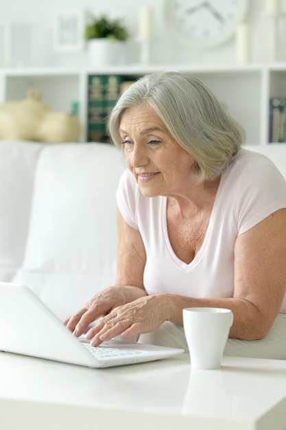 Feliz mulher sênior usando laptop