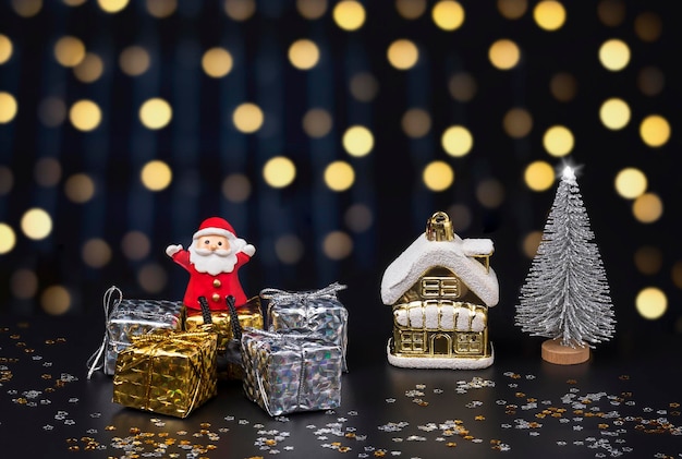 Feliz muñeco de Santa Claus sentado en cajas de regalo con adornos navideños en el fondo de la noche