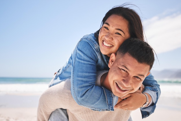 Feliz nas costas e retrato de um casal na praia para um encontro, amor ou férias juntos Sorriso de verão e um homem e uma mulher com um abraço no mar para uma viagem de férias ou união no casamento