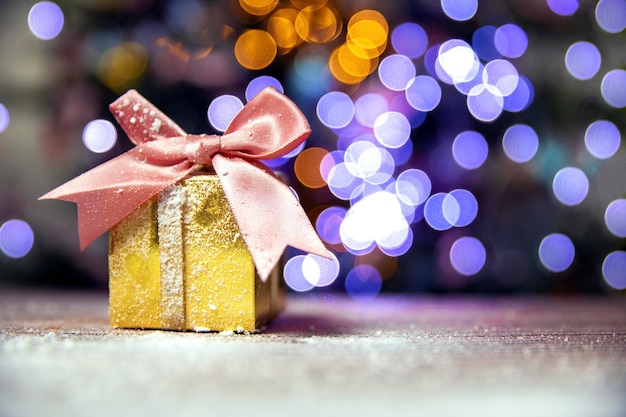 Feliz Natal, Ano Novo, presentes em caixas de ouro com laço rosa na neve, bokeh Fundo da árvore de Natal com espaço de cópia, Férias, conceito presente