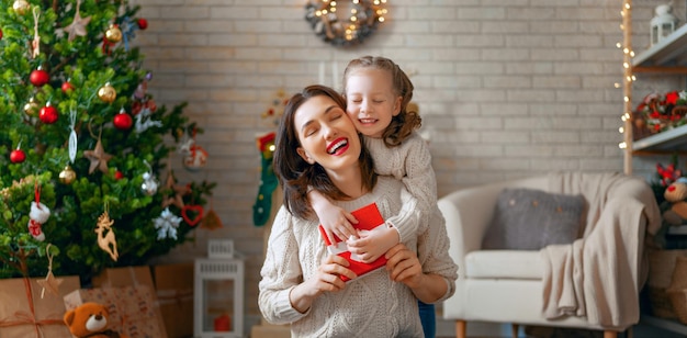 Feliz Natal Boas Festas Alegre mãe e sua linda filha trocando presentes