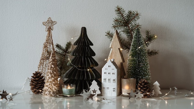 Feliz natal. casinha de cerâmica de natal, pinheiros de madeira. decorações festivas e modernas.