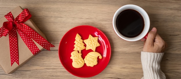 Feliz Natal com a mão de uma mulher segurando uma xícara de café e biscoito caseiro na mesa de férias de véspera de Natal e feliz conceito de Ano Novo