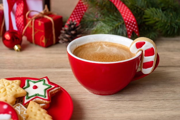 Feliz natal com biscoitos caseiros e xícara de café no fundo da mesa de madeira. conceito de véspera de natal, festa, feriado e feliz ano novo