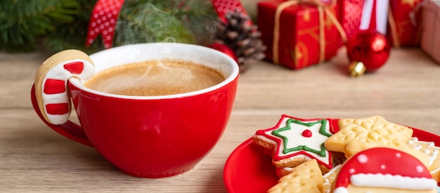 Feliz natal com biscoitos caseiros e xícara de café no fundo da mesa de madeira. conceito de véspera de natal, festa, feriado e feliz ano novo