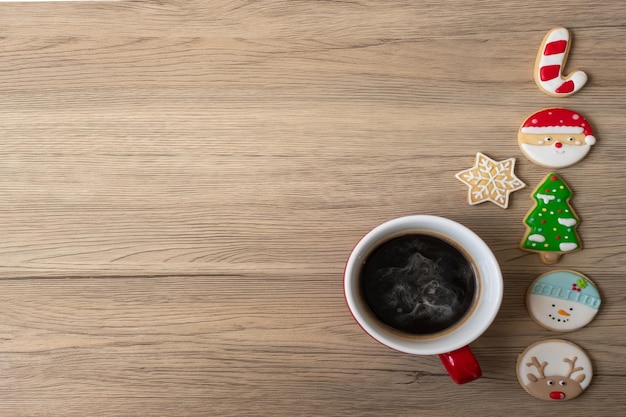 Feliz natal com biscoitos caseiros e xícara de café no fundo da mesa de madeira feriado de festa de véspera de natal e feliz conceito de ano novo