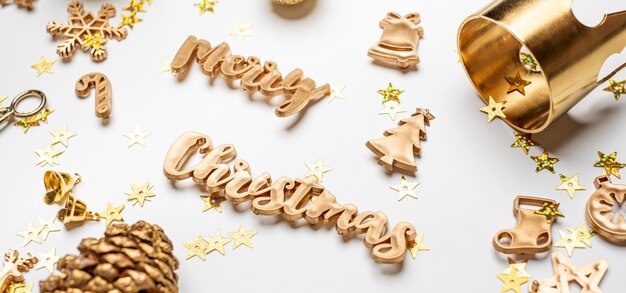 Feliz Natal com texto em ouro e itens de decoração de luxo na mesa branca