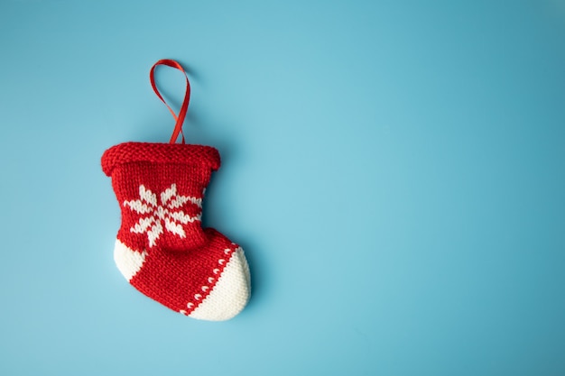 Feliz natal conceito: meia de bebê recém-nascido vermelho sobre fundo azul