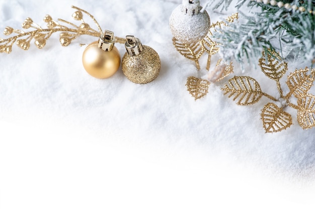 Foto feliz natal. decoração de natal com bola de ouro na neve.