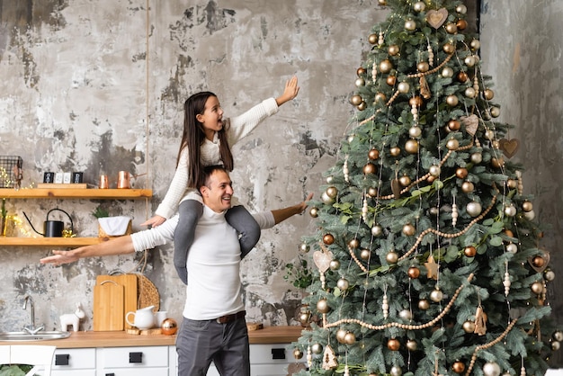 Feliz natal e boas festas. mãe, pai e filha decorando a árvore de natal.