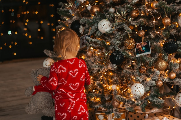 Feliz Natal e Boas Festas. Uma menina de pijama vermelho