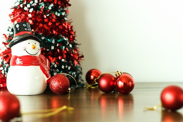 Feliz Natal e decoração feliz ano novo com boneca de neve no chão de madeira.