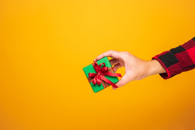 Foto feliz natal e feliz ano novo 2021 mãos masculinas segurando a caixa de presente.