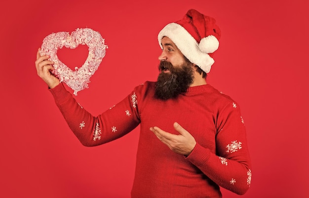 Feliz natal e feliz ano novo Cara usa chapéu de Papai Noel Apaixone-se Eu te amo Deixe-me derreter seu coração Bem-vindo Natal em seu coração Homem bonito amor férias de inverno fundo vermelho