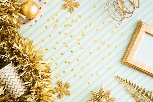 Feliz Natal e feliz ano novo cartão vista do ouropel de ouro, bola, ornamento na mesa