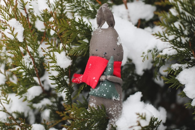 Feliz Natal e Feliz Ano Novo Coelho de brinquedo pendurado em um símbolo de galho de árvore de Natal de 2023