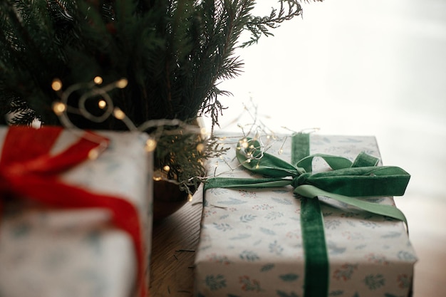 Feliz Natal e Felizes feriados Regalos de Natal enrolados com estilo Luzes e galhos de abeto na mesa em uma sala escandinava festiva Imagem atmosférica