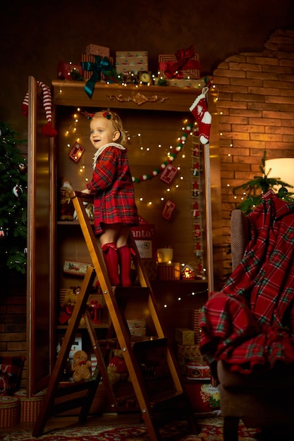 Foto feliz natal e felizes feriados uma menina num vestido a xadrez