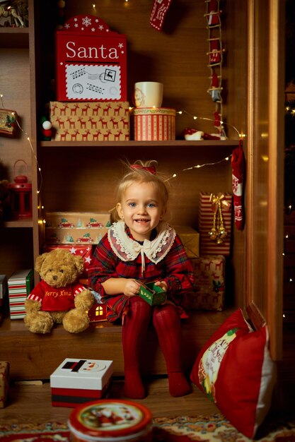 Foto feliz natal e felizes feriados uma menina num vestido a xadrez