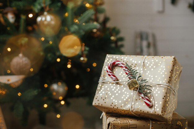 Feliz Natal elegantes presentes de natal com bastão de doces na árvore de natal com bokeh de luzes douradas