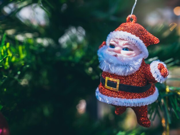 Feliz Natal enfeites de papai noel fofo pendurado no fundo verde da árvore de natal