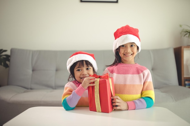 Feliz natal, irmãs felizes, com um presente em casa