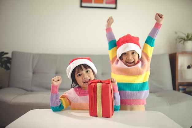 Feliz Natal, irmãs felizes, com um presente em casa